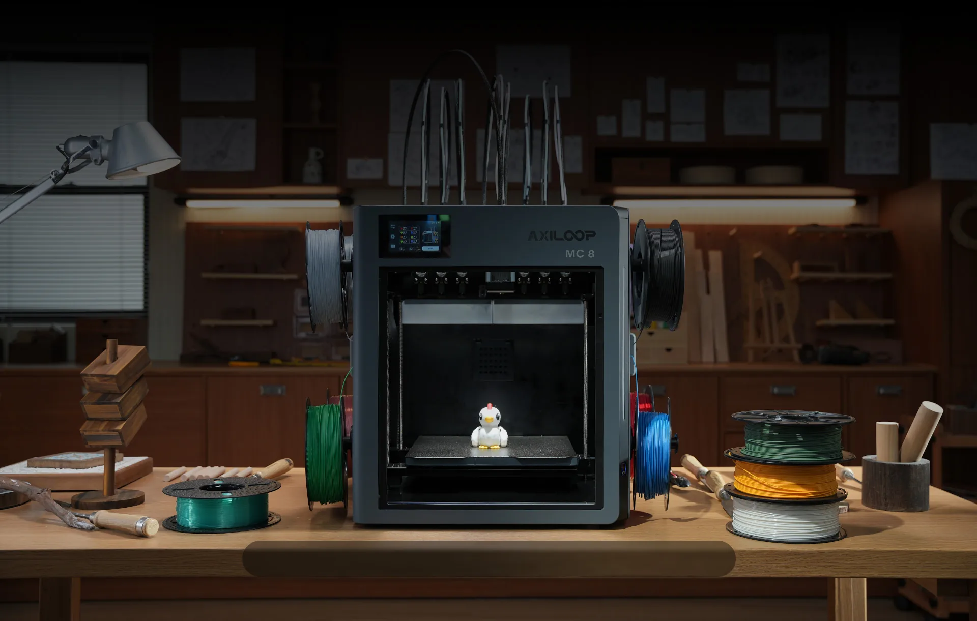 The Axiloop MC8 3D printer on a workshop table, surrounded by colorful filament spools.